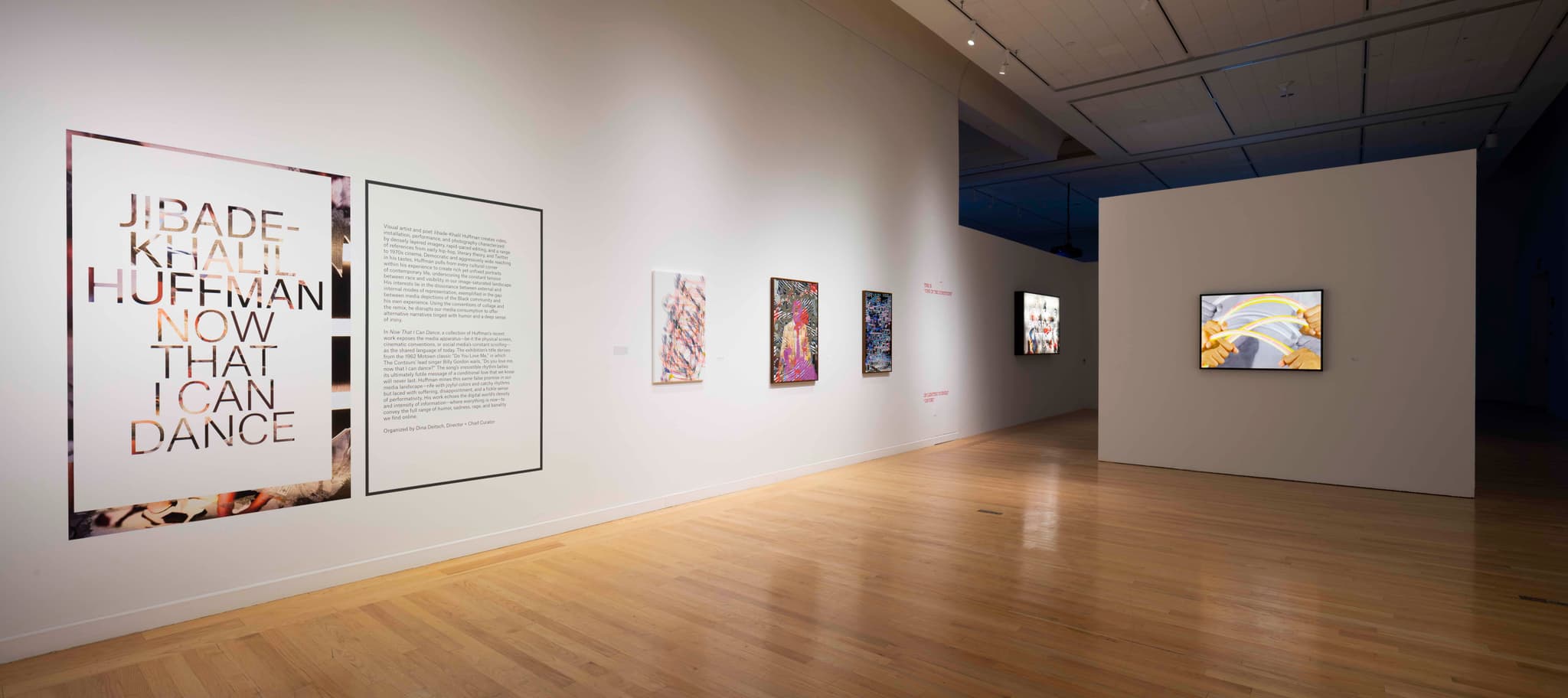 Works of art by Jibade-Khalil Huffman, including one representing rainbows, appear on the white walls of the gallery.